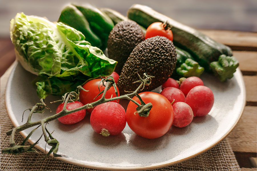 Gemüseteller mit Radieschen, Tomaten, Salat, Avocado, Zucchini und Paprika